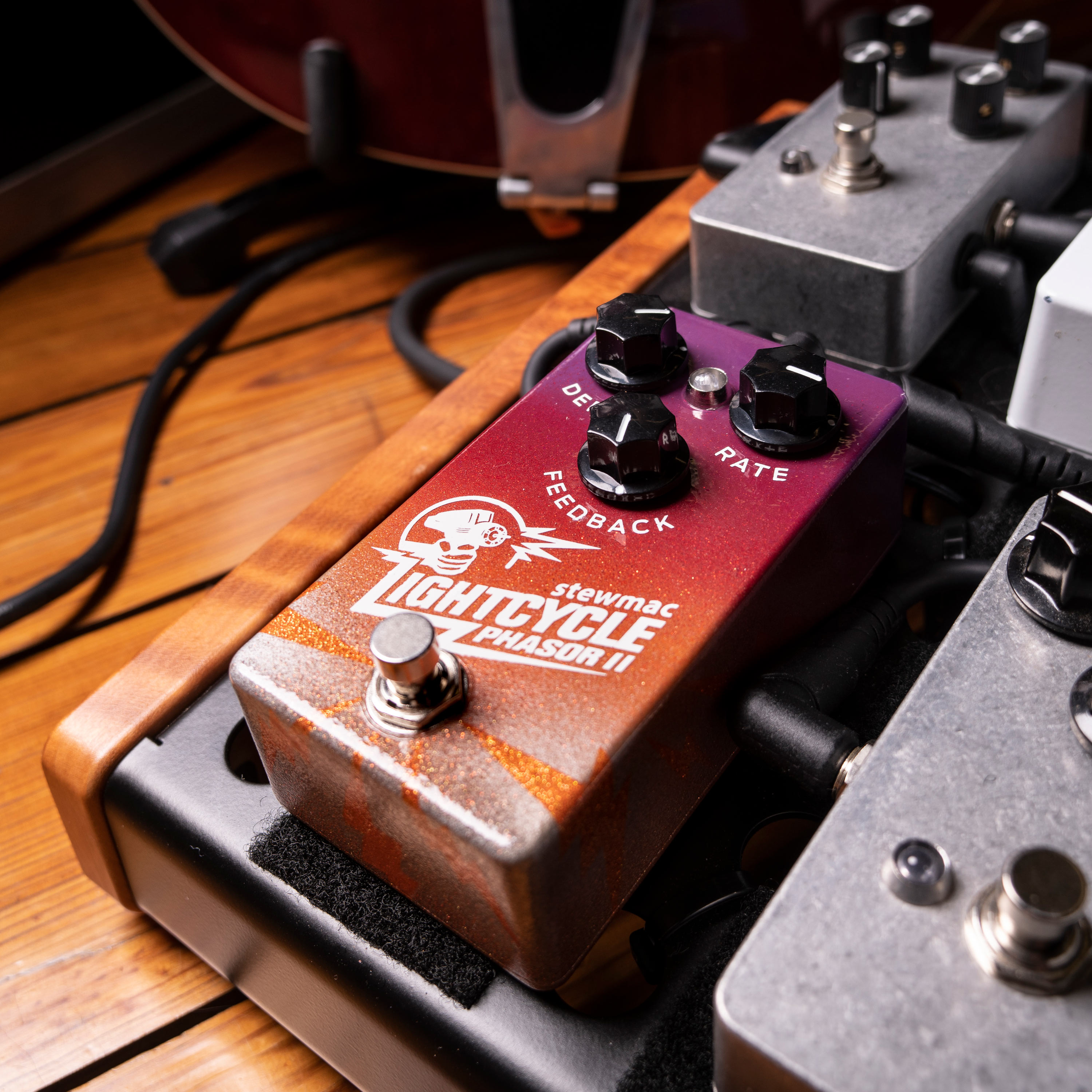 Lightcycle Phasor II Pedal auf Pedalbrett mit Gitarrenkabeln auf dem Boden.