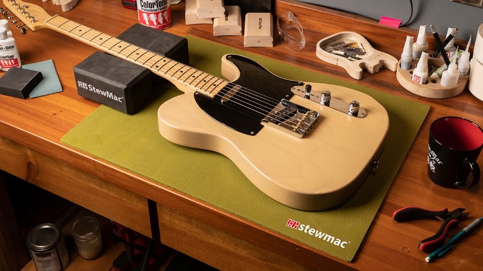 Luthier-Werkbank mit Fender Telecaster-Gitarre, umgeben von StewMac-Tools.