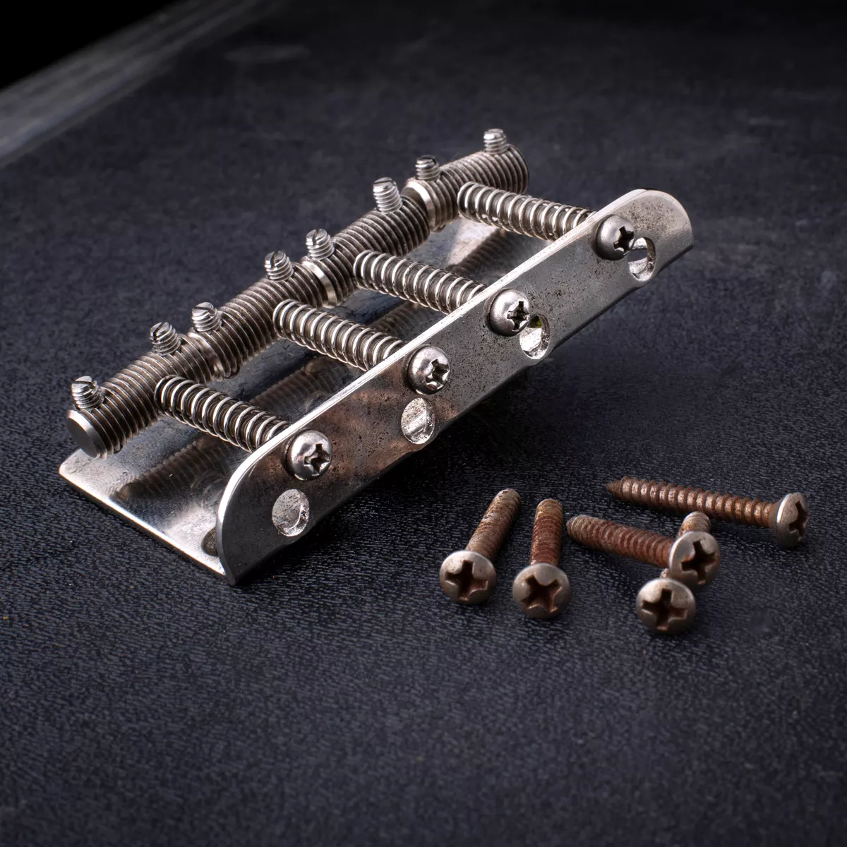 „GuitarSlinger Cryocated Aged“-Steg für 4-Saiter-Bass mit Threaded-Rod-Saitenreitern „GuitarSlinger Cryocated Aged“-Steg für 4-Saiter-Bass mit Threaded-Rod-Saitenreitern