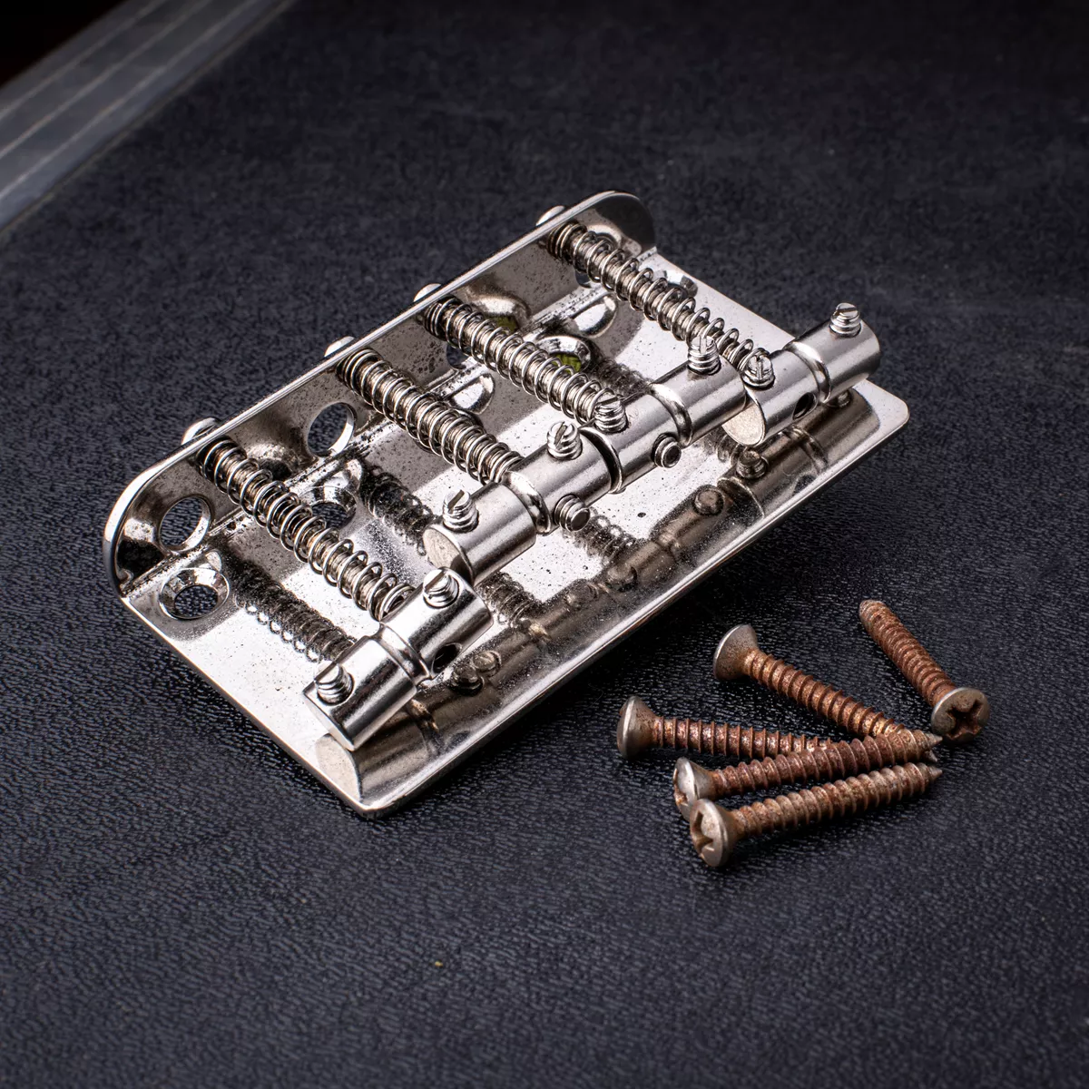 „GuitarSlinger Cryocated Aged“-Steg für 4-Saiter-Bass mit Grooved-Barrel-Saitenreitern „GuitarSlinger Cryocated Aged“-Steg für 4-Saiter-Bass mit Grooved-Barrel-Saitenreitern