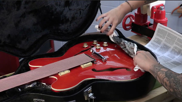 Packen einer Gitarre in einen Versandbehälter