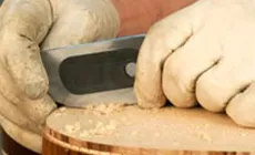 Halten Sie den Schaber fast vertikal, während Sie mit den Daumen drücken.