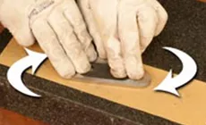 Die Seiten mit einer kreisförmigen Bewegung auf einem Schärfstein (oder feinem Schleifpapier auf einer glatten Oberfläche, wie hier gezeigt) flach und glatt machen.