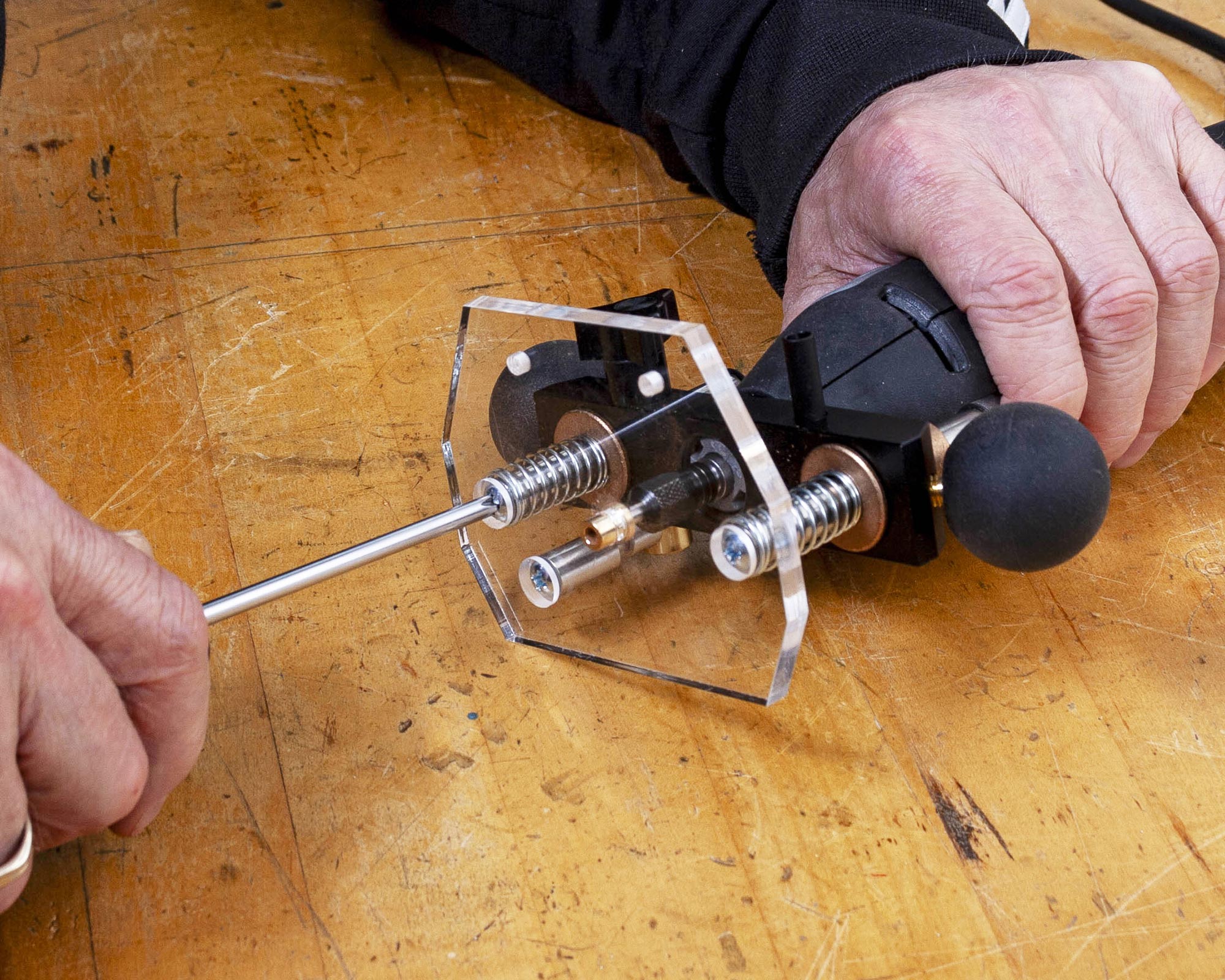 Ziehen Sie die unteren Schrauben in der Griffbretteinlage fest.