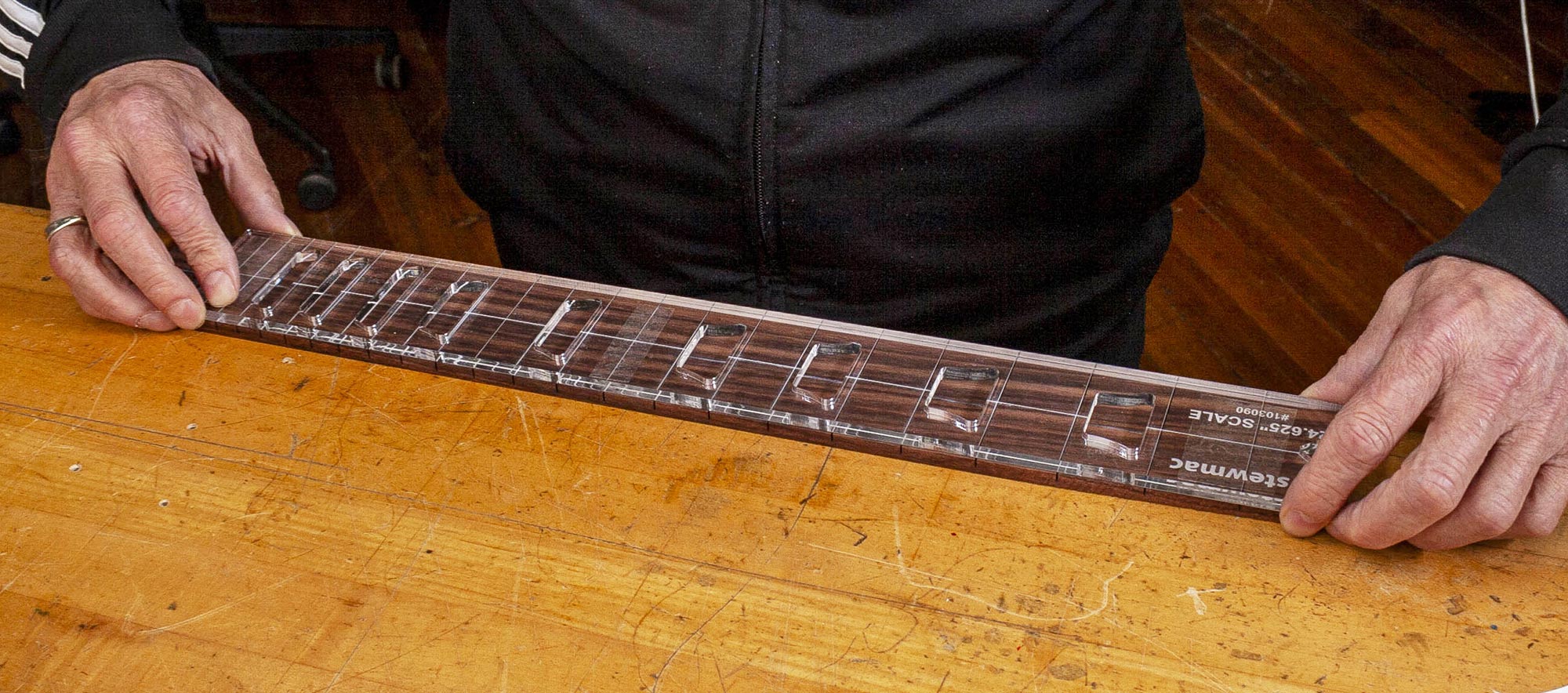 Richten Sie die Griffbretteinlage an der Griffbrett aus.