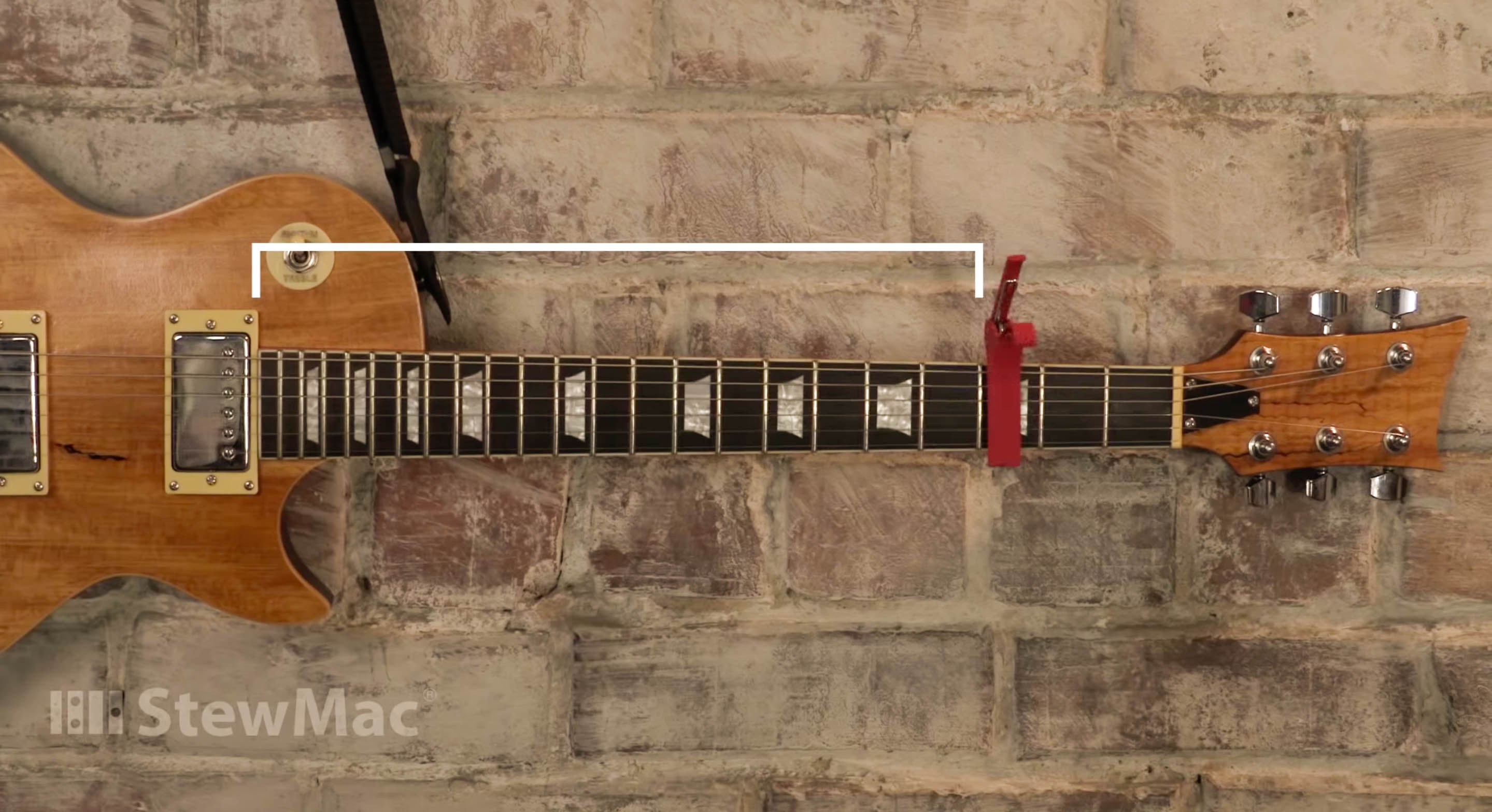 Capo an den Strängen auf dem Brett befestigt