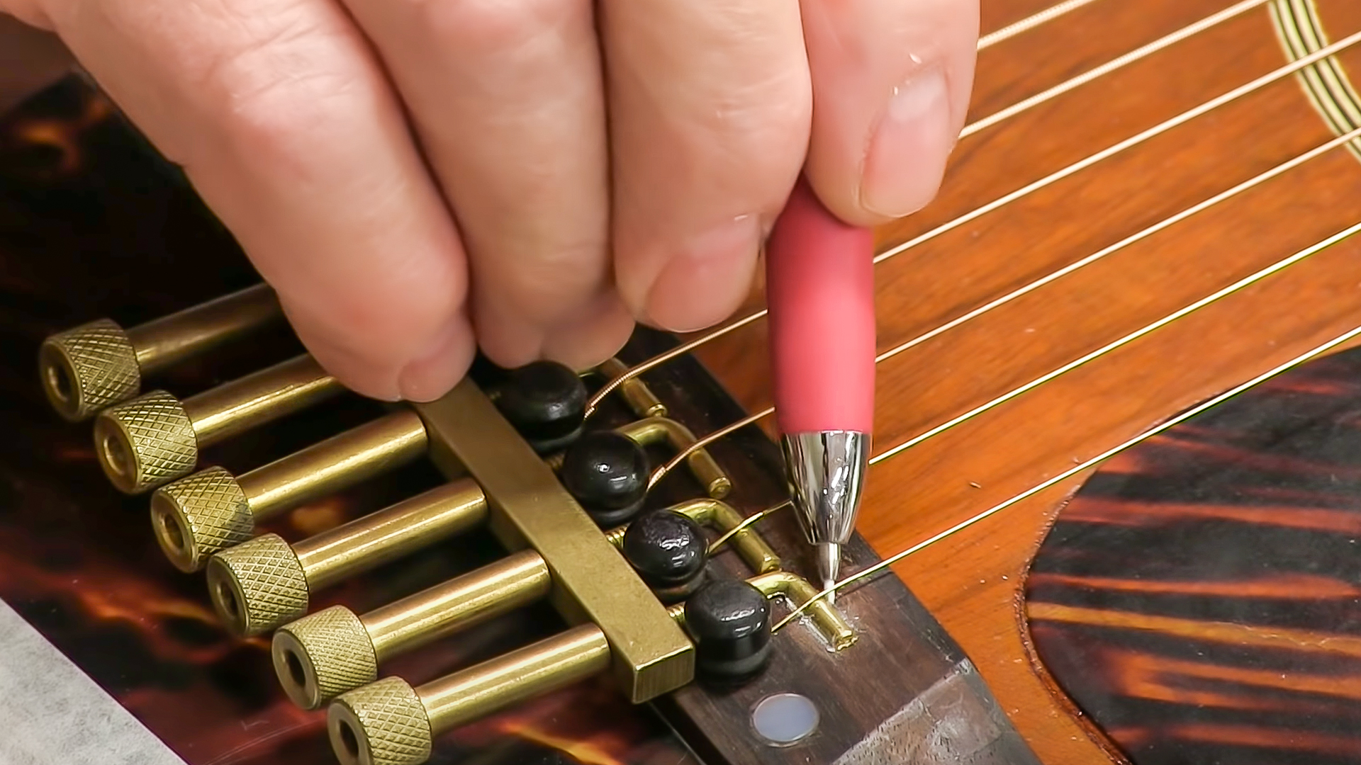Wo kann man den Sattelschlitz auf dieser Gitarrenbrücke schneiden?